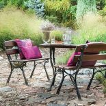 Proste meble ogrodowe i kolorowe, eleganckie poduszki.