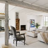 Prosty salon ożywiają: bogate lustro, czarne ludwiki, kandelabr i obraz Jeana de Paula.