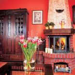 Przed kominkiem popielnik, w którym pani domu trzyma świece.