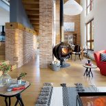 Przepis na soft loft. Szare ściany i fragmenty czerwonego muru, a do tego dużo ciepłego drewna.