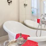 Przestronna łazienka z wolnostojącą wanną na ozdobnych, lwich nóżkach.