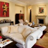 Przestronny salon urządzono klasycznie - wygodne kanapy, przed kominkiem fotele. Widać tu także zamiłowanie do