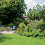 Przeważające w ogrodzie odcienie żółci i zieleni wprowadzają słoneczną, wakacyjną atmosferę.