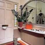 Przy drzwiach wisi lustro w srebrnej ramie.