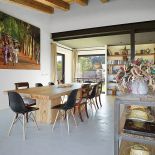 Przy dużym drewnianym stole postawiono krzesła w różnych stylach: nowoczesne i artdecowskie.