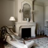 Przy kominku stoi szezlong. Zameczek dla dwojga