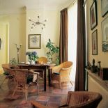 Przy kuchennym stole wiklinowe krzesła.