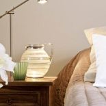 Przy łóżku dzbanek i szklanka. Dom gościnny