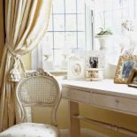 Przy oknie stoi konsola i krzesło. Francuski klucz