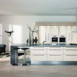 Przy wyspie znalazło się miejsce na dwa krzesła barowe. Pomalowane na biało dębowe fronty i laminaty w kolorze piaskowym