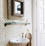 Rama lustra była kiedyś podstawą ogromnej stołowej nogi. Teraz rozkwita na tle kafelków w subtelny wzór.