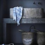 Leciutkie rattanowe fotele i ławki, kosze uplecione z morskich traw, lniana pościel w kolorze indygo,