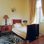 Rozłożone na podłodze skóry zebry i tygrysa dodają empirowej sypialni egzotyki.