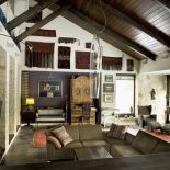 Salon z kamienia i drewna z otwarty stropem.