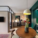 Przykład zagospodarowania kuchni, salonu i pracowni w jednym pomieszczeniu, bez oddzielania stref ścianami. To pomysł