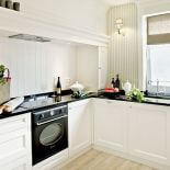 Zamiast kafelków, ścianę wokół aneksu kuchennego dyskretnie chronią panele. Fot. Rafał Lipski