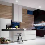 Ściana kuchenna jak obraz z bielą szafek, drewnianą okładziną i okienkami. Model SmartDesign (Siematic). STUDIO FORMA 96