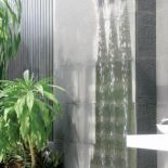 Ściana wodna wyłożona czarnymi kamiennymi płytami. GARDENARIUM