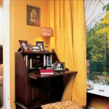 Sekretarzyk przy wielkim oknie z widokiem na ogród - wymarzone miejsce do pracy.