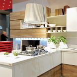 Kuchnia urządzona nowocześnie z okapem kuchennym nad wyspą.