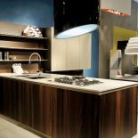 Kuchnia urządzona nowocześnie z okapem kuchennym nad wyspą.