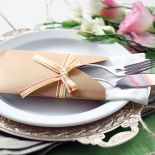 Sztućce i serweta wetknięte w papierową kopertę z kokardą - oryginalnie