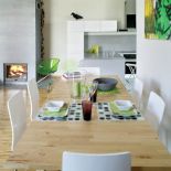 Skandynawskie biele, szarości oraz jasne drewno zostały ożywione zielenią. Proste krzesła kupili w Kare Design.