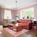 Skórzana kanapa o fotel obszyty tkaniną w kratę.