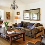 Skórzane fotele i drewniany stolik. Przepis na przytulny dom