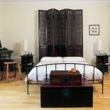 Stara brama na podwórze awansowała do roli parawanu, który zdobi wezgłowie łóżka.