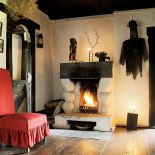 Stary kominek ozdobiony okrągłymi kolumnami ulepionymi z gliny przez artystę.