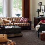 Stolik w kształcie kufra i walizka w roli gazetownika - aż chciałoby się gdzieś pojechać. Aranżacja firmy JAB ANSTOETZ.