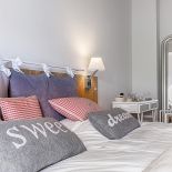 Styl skandynawski: biele błękity i szarości na tle drewnianej ściany. W domu pomieszano wiele stylów