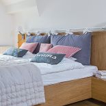 Styl skandynawski: biele błękity i szarości na tle drewnianej ściany. W domu pomieszano wiele stylów