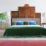 W SYPIALNI ZA WEZGŁOWIEM ŁÓŻKA STOI DEKORACJA Z DRZWI POCHODZĄCYCH Z BAROKOWYCH SZAF. PO PRAWEJ STOLIK DO GRY W