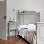 Stylowe łóżko i stonowane kolory nadają sypialni godną oprawę.