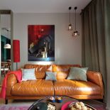 Asymetryczne zawieszenie lamp na suficie jest zrównoważone dzięki obrazowi.