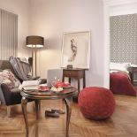 Czerwony puf przełamuje szarości we wnętrzu.