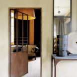 Surowe blaszane sprzęty, a w głębi za drzwiami - stylowa kanapa.