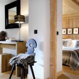 Surowe drewno, biel ścian, do tego proste i naturalne dekoracje w odcieniach czerni, bieli i szarości.