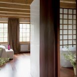 Sypialnia jest oddzielona od łazienki delikatnym przepierzeniem zrobionym z drewna i matowego szkła.