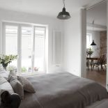 Sypialnia w mieszkaniu na Powiślu oddzielona jest od salonu z kuchnią przesuwanymi drzwiami. Projekt: KWStudio.