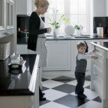 Szachownica na podłodze w kuchni i blaty z czarnego kamienia harmonozują z całością wystroju.