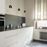 Szafki zaprojektowane przez Agnieszkę Pudlik. Granitowy blat do prostych mebli. Ten sam kamieć jest położony na ścianie.