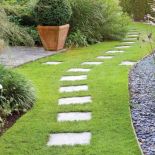 Szare betonowe płyty w trawniku dobrze grają z kora wysypana na rabatach. GAP PHOTOS/MEDIUM