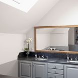 Szare meble zostały połaczone z dodatkami z naturalnego, starego drewna.