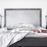 Szarości i biel to kolory, które dominują w sypialni.