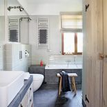 Szary gres, oliwkowe płytki i dąb - trzy różne materiały, a do siebie pasują.