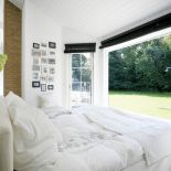 Szklana ściana sprawia, że ogród zdaje się wdzierać do wnętrza.