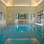 Szlachetne szarości, marmurowe posadzki, przeszklone schody, lustra i stal.